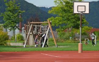 A streetball court on the roof of an underground car park. The surface is permeable down as far as the drainage layer. Roof garden with swings and streetball court